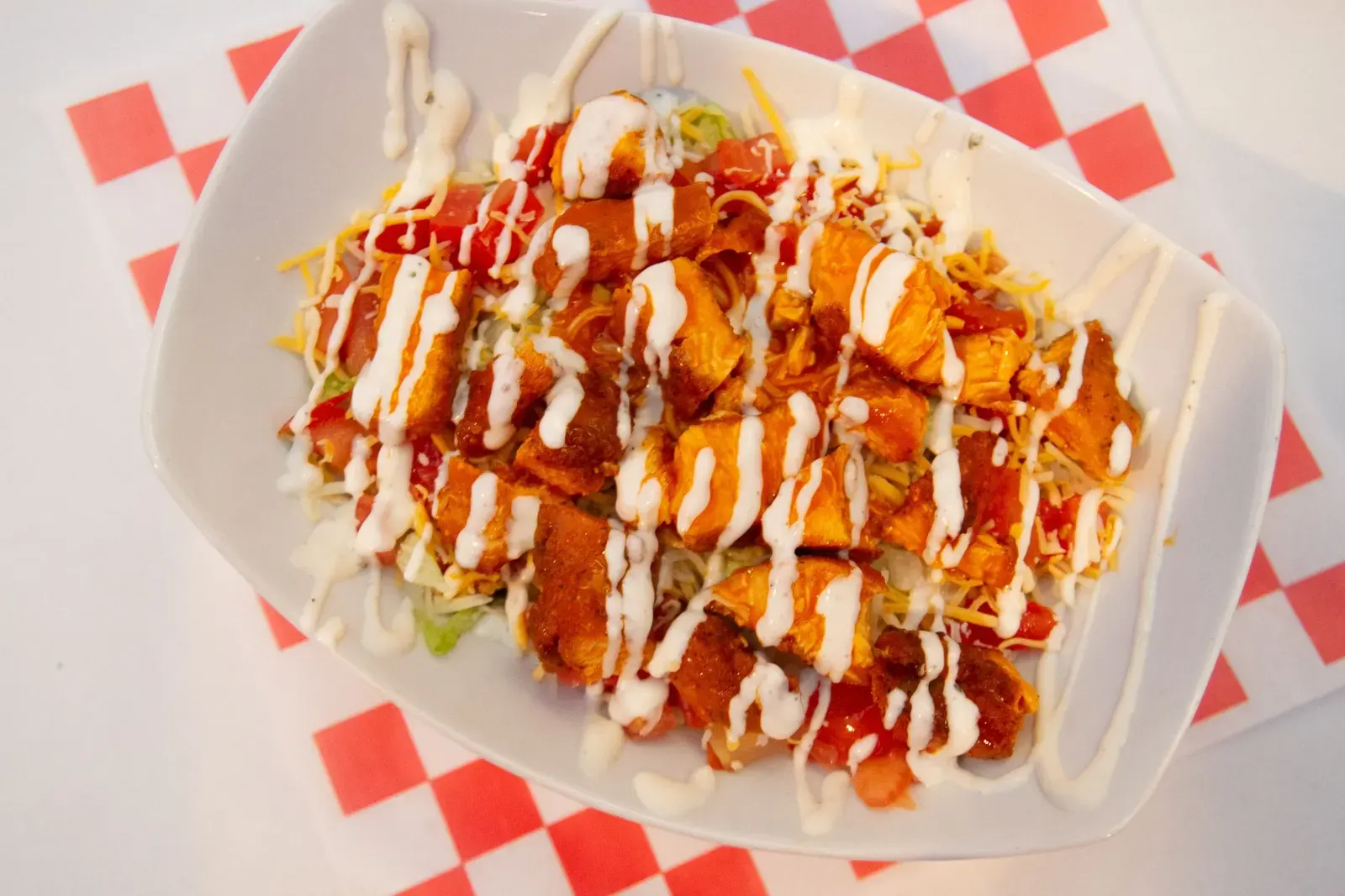 Scorers buffalo chicken salad topped with crispy chicken, ranch dressing, tomatoes, cheese, and cucumbers